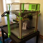 shows Solidoodle 3 printer with plexiglass enclosure with webcam - all printed add-ons used fluorescent green plastic.